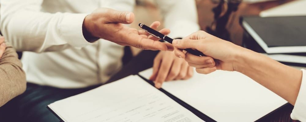 Man Grabbing Pen to Sign Papers
