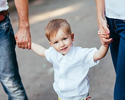 child between parents holding hands